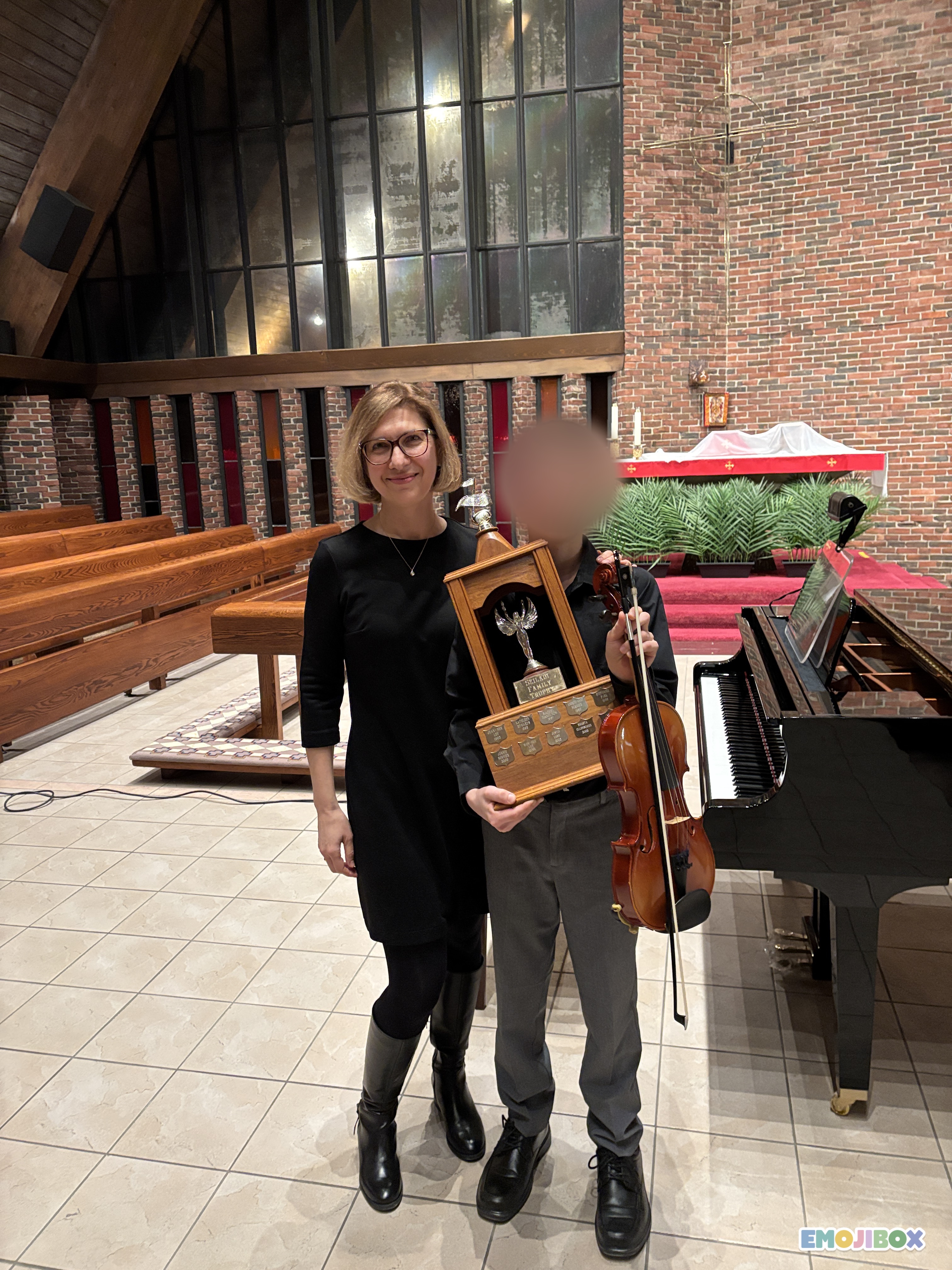 Dennis Finch holding the Musicianship Trophy beside Mira
